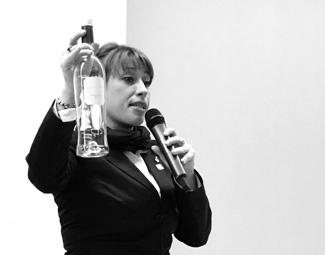 Clizia Zuin holding a bottle and a microphone