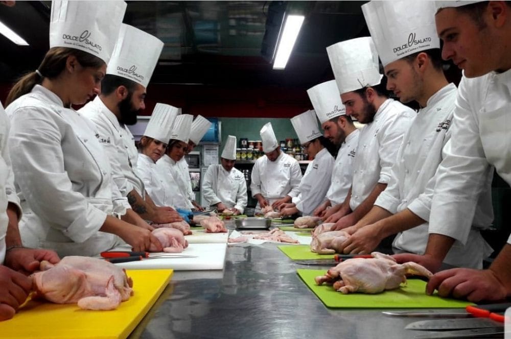 Gruppo di chef attorno a un tavolo durante un corso di formazione.