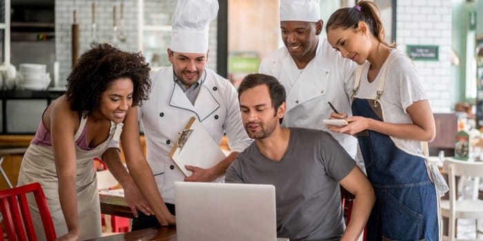 Staff di un ristorante che sta pianificando il lavoro attorno a un computer