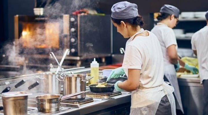 Chef in cucina che prepara un piatto